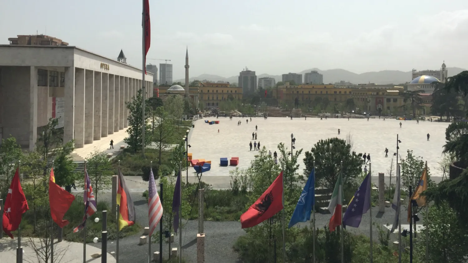 Një grup profesionistësh të shëndetit mendor të mbledhur rreth një tavoline në një takim, me logot e OBSH-së dhe UNICEF-it, duke simbolizuar përpjekjet ndërkombëtare për reforma.