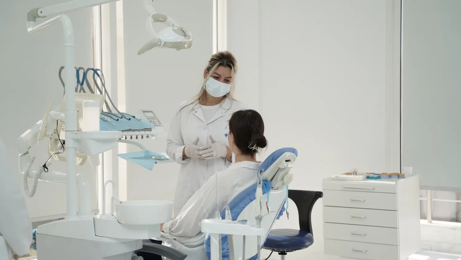 Dentiste duke konsultuar një paciente në një klinikë dentare moderne, duke ilustruar shërbimet cilësore të ofruara.