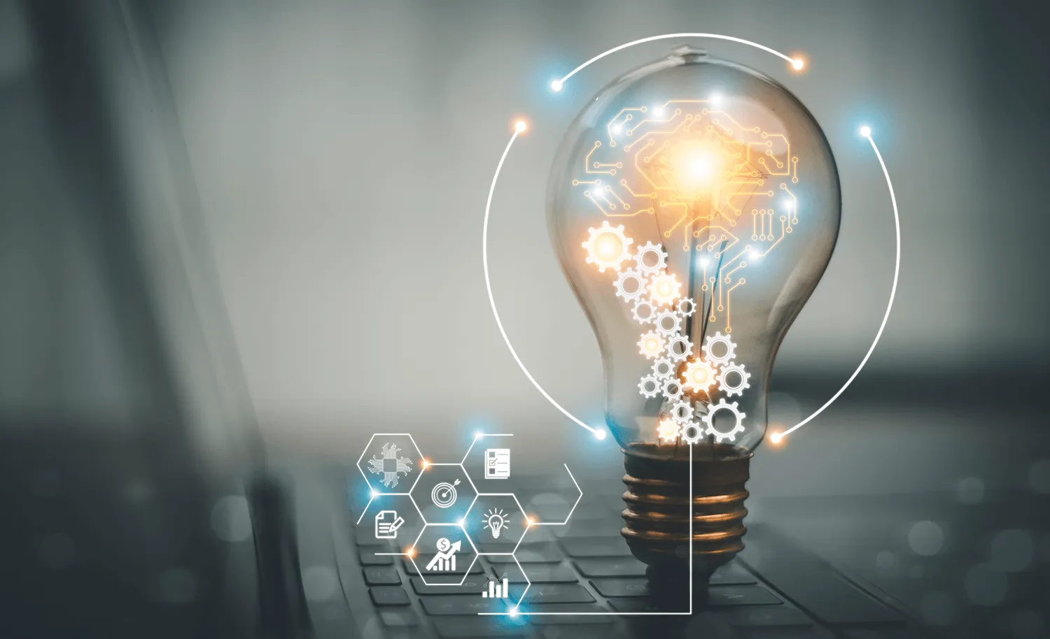 Një llambë drite me qark elektronik brenda saj, vendosur mbi një tastierë laptopi, duke simbolizuar idetë, inovacionin dhe transformimin digjital.