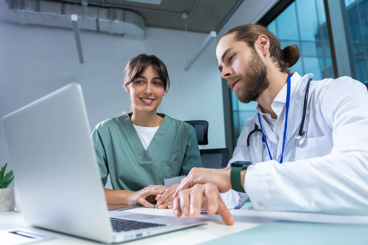Një infermiere dhe një mjek duke rishikuar të dhënat e pacientit në një laptop.