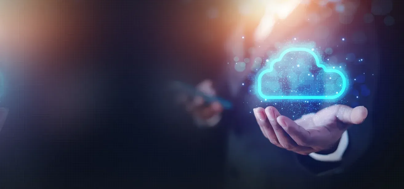 Një dorë mban një simbol ndriçues të resë kompjuterike (cloud), duke simbolizuar transformimin dixhital dhe shërbimet cloud.
